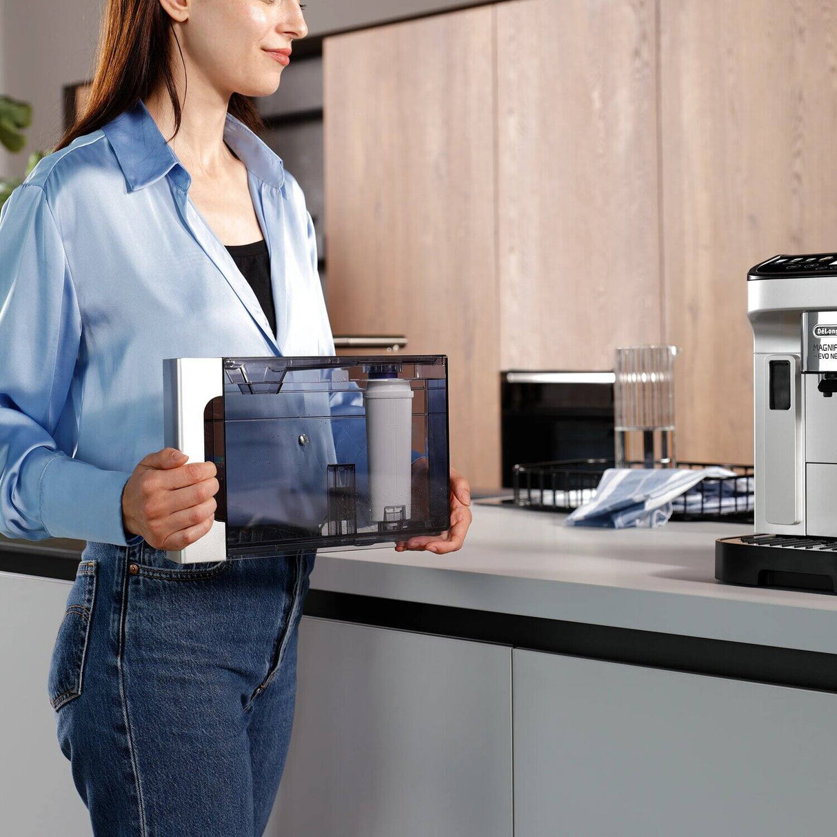 De'Longhi water tank with DLSC002 filter beside a fully automatic coffee machine